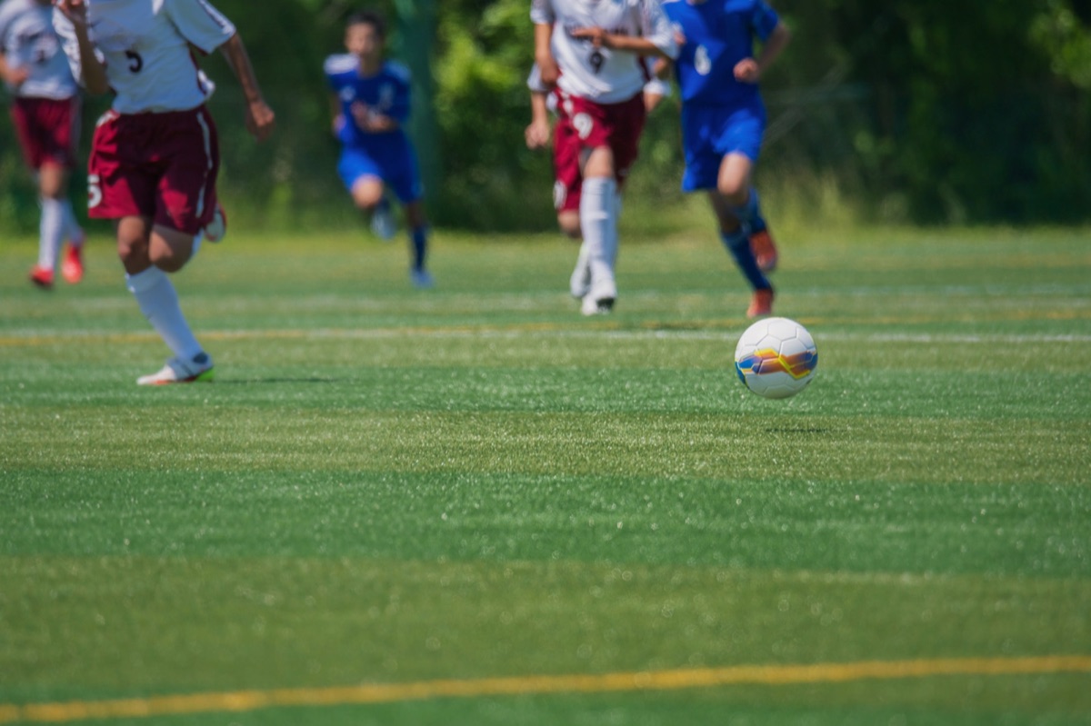 試合でボールを追う小学生