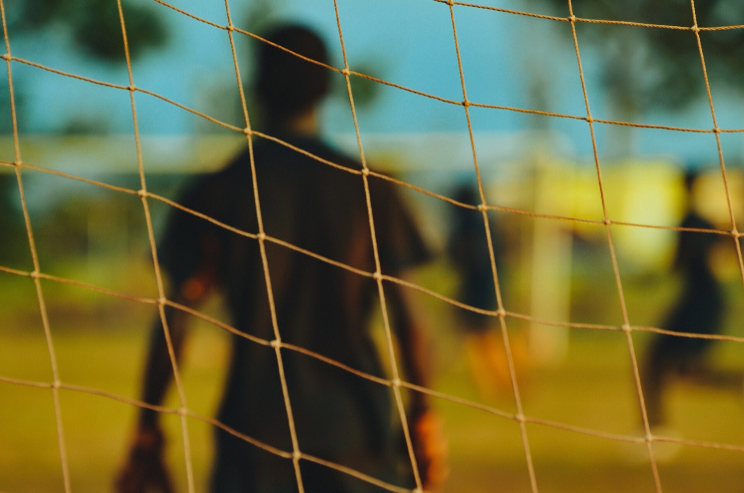 ゴールネット越しに見るサッカーのピッチ